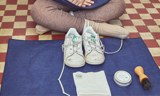 Une activité montessori est présentée sur un tapis devant une petite fille assise