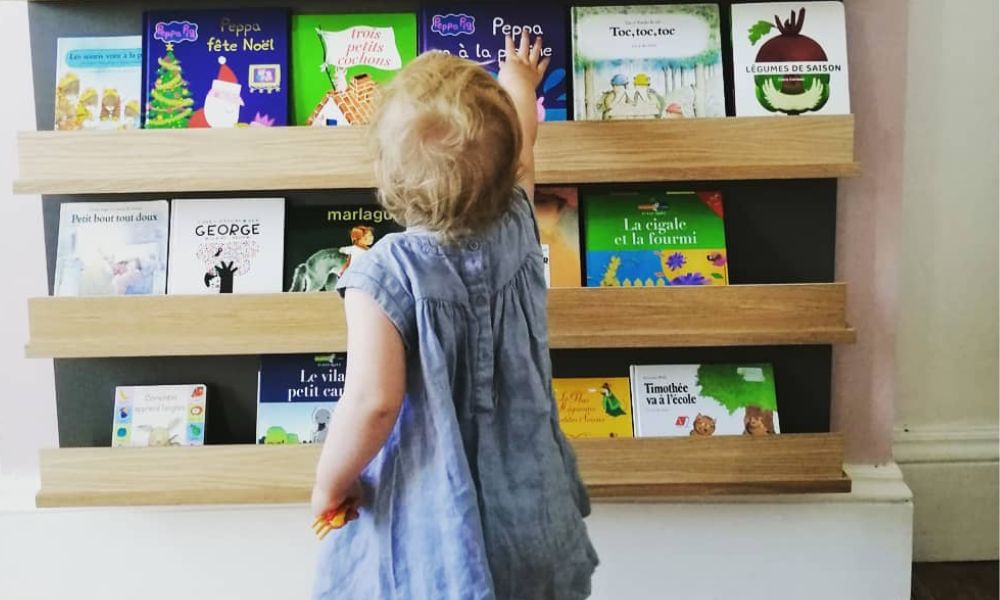 Fille de 2 ans se dirigeant en autonomie vers sa bibliothèque