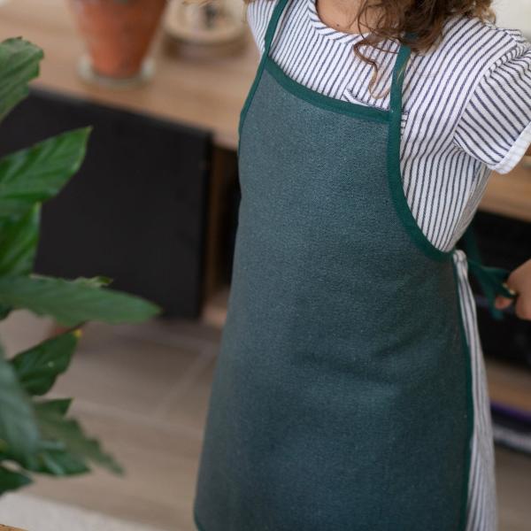 petite fille qui noue son tablier